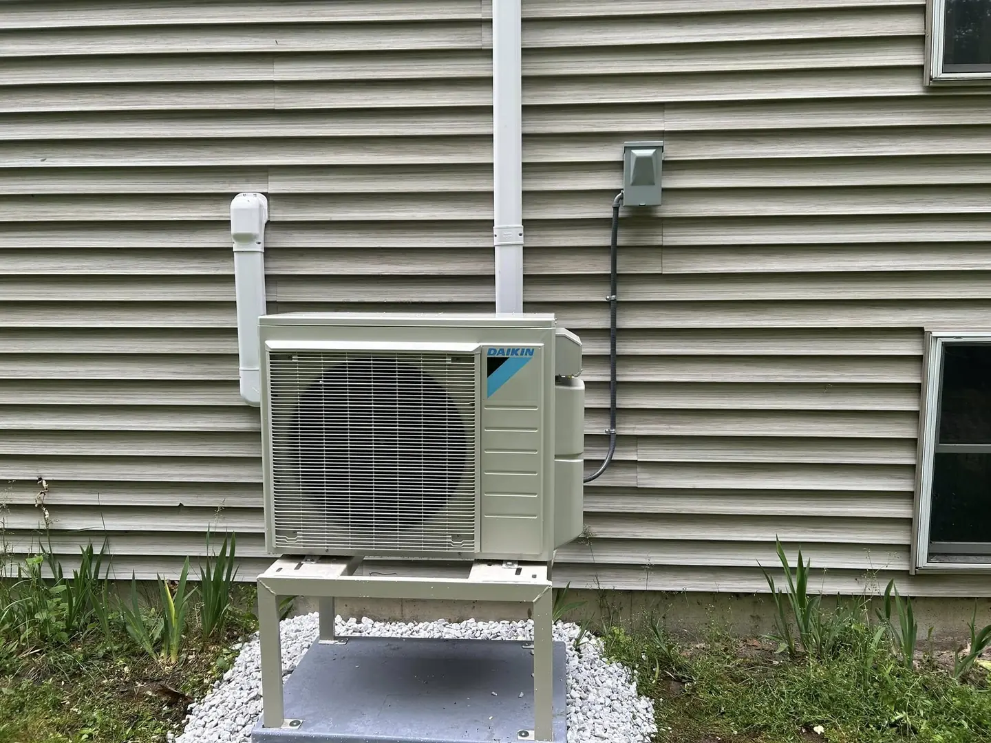Outdoor heat-pump condenser beside a home